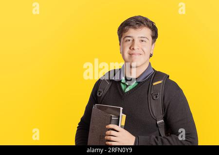 Portrait of a young caucasian student isolated on yellow background with copy space. Stock Photo