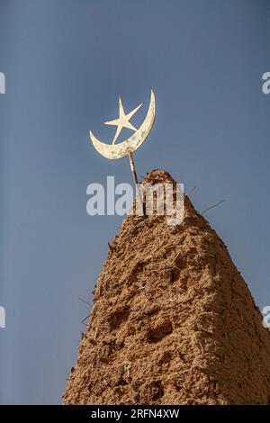 Star and Crescent symbol on top of a mud mosque in Mali , West Africa Stock Photo