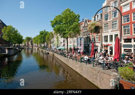 People relaxing in cafes along the Oudezijds Voorburgwal canal, Amsterdam, Netherlands Stock Photo