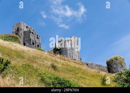 Different view of Corfe Castle on the Isle of Purbeck Dorset. Looking up from the public footpath around the base of the hill. Stock Photo