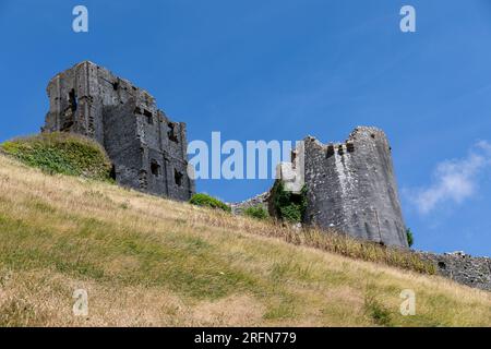 Different view of Corfe Castle on the Isle of Purbeck Dorset. Looking up from the public footpath around the base of the hill. Stock Photo