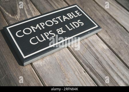 A sign on a designated recycling bin accepting compostable takeaway coffee cups and lids with copy space Stock Photo
