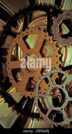 Cog wheels of bicycles and  part of a wheel cover on a black background. Steampunk background. Bicycle. Technical. Mechanical parts. Gears. Cogwheels Stock Photo