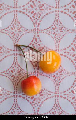 two attached Rainier cherries on moroccan pink and white patterned platter Stock Photo