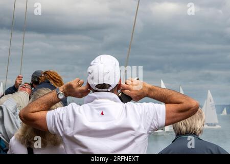 man with fingers in his ears to protect them from bang of the starting cannons at the annual cowes week yachting and sailing regatta isle of wight. Stock Photo