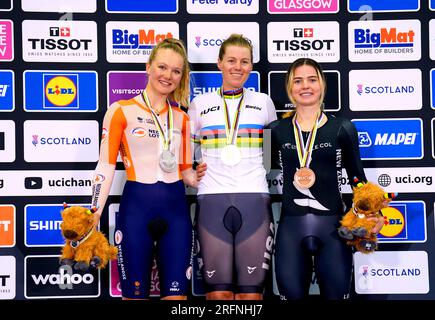 USA's Jennifer Valente (centre) celebrates on the podium after winning gold in the Women's Elite Scratch Race alongside Netherlands' Maike van der Duin (left), who won silver and New Zealand's Michaela Drummond, who won bronze, during day two of the 2023 UCI Cycling World Championships at the Sir Chris Hoy Velodrome, Glasgow. Picture date: Friday August 4, 2023. Stock Photo