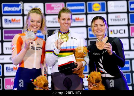 USA's Jennifer Valente (centre) celebrates on the podium after winning gold in the Women's Elite Scratch Race alongside Netherlands' Maike van der Duin (left), who won silver and New Zealand's Michaela Drummond, who won bronze, during day two of the 2023 UCI Cycling World Championships at the Sir Chris Hoy Velodrome, Glasgow. Picture date: Friday August 4, 2023. Stock Photo