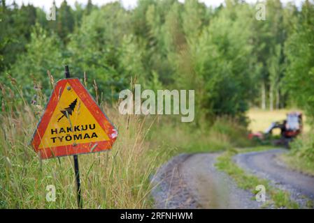 Nokia, Finland - July 31, 2023:  Woodworking site warning sign and forestry machinery on sunny July evening in Western Finland. Stock Photo