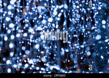 An abstract photo of some blue Christmas light decorations. This was a setting of trees and snowmen figurines. Stock Photo