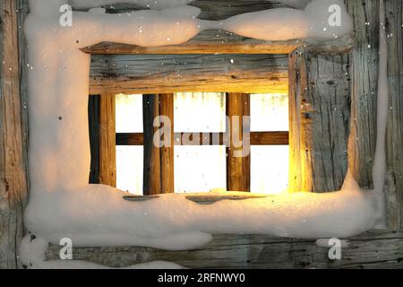 Old frozen window with falling snow outside. Christmas background. Stock Photo