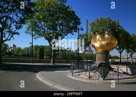 Paris, France - May 07 2018: Flamme de la Liberté near Pont de l'Alma with behind, the Eiffel Tower and the Cathédrale de la Sainte-Trinité. Stock Photo