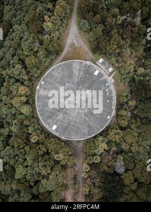 A water tower located on top of a hill. The shot was taken from a drone looking directly down on it. Stock Photo