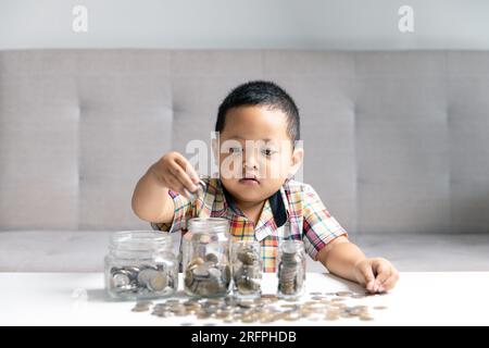 Preschooler child learning to calculate personal budget, manage finance, playing investment, accounting. Focused school kid saving money for purchase, Stock Photo