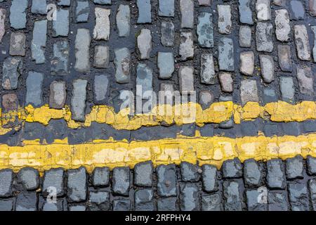 Double yellow lines on cobbled street, closeup Stock Photo