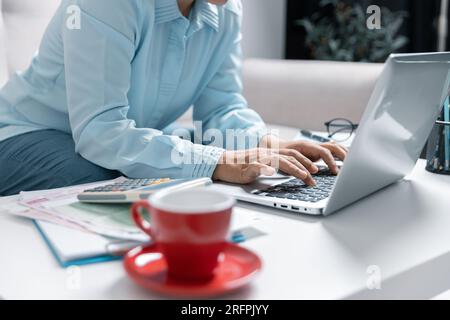 Concentrated Asian woman calculating expenditures, analyzing paper bank bills, managing monthly budget, planning investment, paying for service or uti Stock Photo