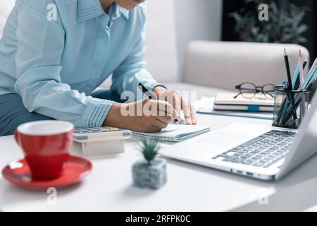 Concentrated Asian woman calculating expenditures, analyzing paper bank bills, managing monthly budget, planning investment, paying for service or uti Stock Photo