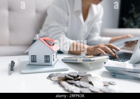 Concentrated Asian woman calculating expenditures, analyzing paper bank bills, managing monthly budget, planning investment, paying for service or uti Stock Photo