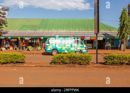 Turquoise van with multi-colored spots parked in front of a shopping center in Jinja, Uganda. Stock Photo
