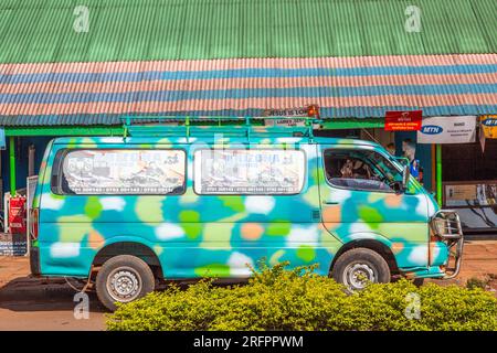 Turquoise van with multi-colored spots parked in front of a shopping center in Jinja, Uganda. Stock Photo
