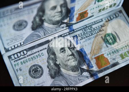 China. 05th Aug, 2023. In this photo illustration, 100 dollar bills seen displayed on a table. Credit: SOPA Images Limited/Alamy Live News Stock Photo