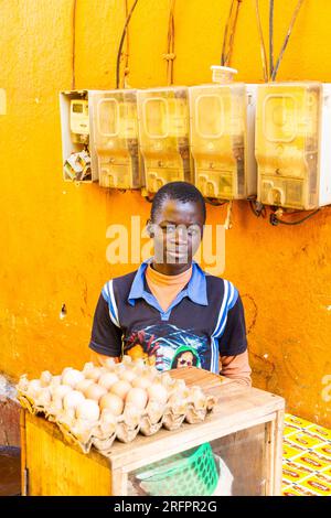 Young egg seller in the market of Jinja, Uganda. Yellow environment. Stock Photo