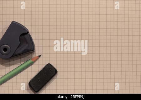 Pencil, pencil sharpener and an eraser isolated on a white background with a square pattern with copyspace (aka empty text space). School background. Stock Photo