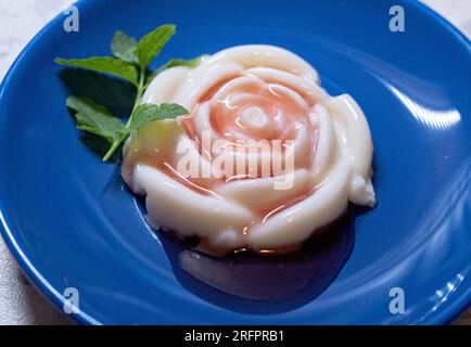 Panna cotta jelly with strawberry sauce and fresh mint on a plate Stock Photo