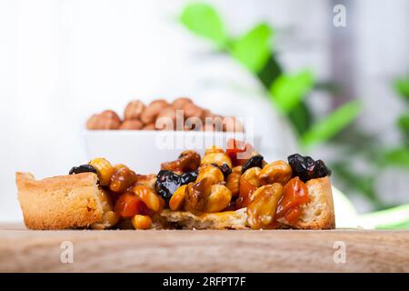 nut tartlet covered with a layer of liquid caramel, high calorie dessert made of dough with natural ingredients, tartlet stuffed with hazelnuts, peanu Stock Photo