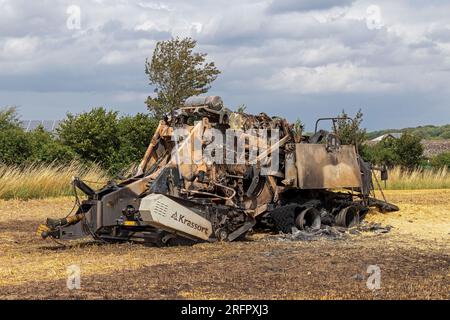 Burnt-out combine harvester, Steinbergkirche, Steinberg, Schleswig-Holstein, Germany Stock Photo