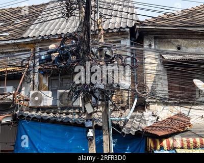 In Bangkok, Thailand, an electrical installation showcases a chaotic array of tangled cables. Stock Photo