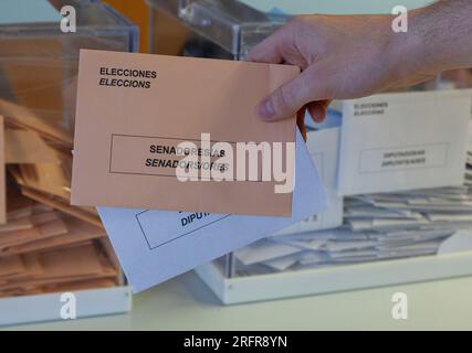 Hand putting a vote in a ballot box with blurred background, closeup Stock Photo