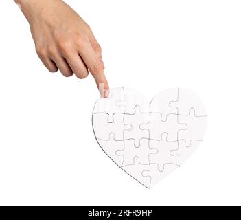 Completing fixing heart shaped puzzle isolated on white background. Love and family psychology concept. Stock Photo