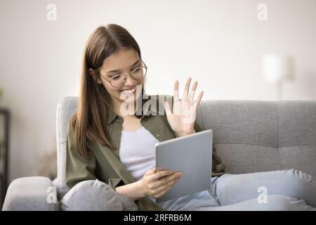 Happy pretty teenager girl in stylish eyeglasses saying hello Stock Photo