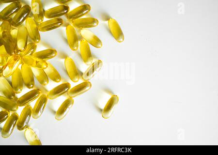 Fish oil capsules, omega 3, on white surface. Oil filled capsules, softgel of food supplements. Stock Photo