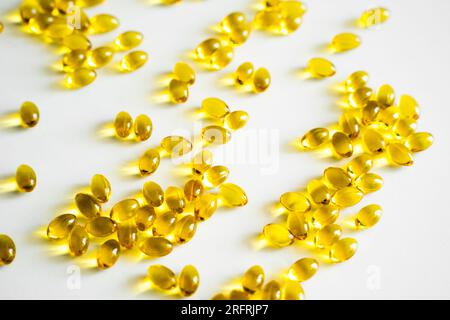 Oil filled capsules, softgel of food supplements. Vitamin D3. Yellow softgels, top view, copy space. Nutritional supplements. Stock Photo