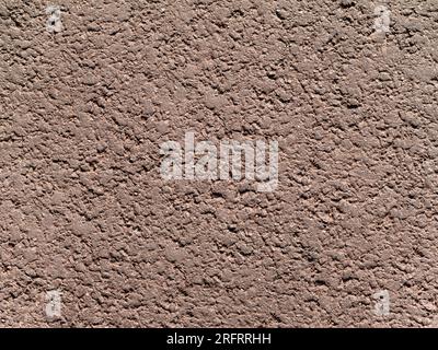 Uneven granular texture of dry compacted earth or sand of light gray-brown beige color Stock Photo