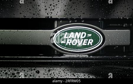 Neu-Ulm, Bavaria, Germany - July 26, 2023: Close up of front of a Land Rover. Car logo on metallic surface with rain drops. Stock Photo