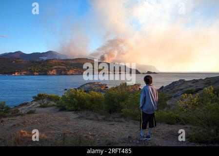 Colera, Spain. 05th Aug, 2023. A man looks at the Colera fire at dawn surrounded by a cloud of smoke. A fire broke out in Portbou and Colera (Girona, Catalonia, Spain) on Friday 4 August, forcing residents to be confined to their homes. It is estimated that a total of 573 hectares have been affected. (Photo by Ximena Borrazas/SOPA Images/Sipa USA) Credit: Sipa USA/Alamy Live News Stock Photo