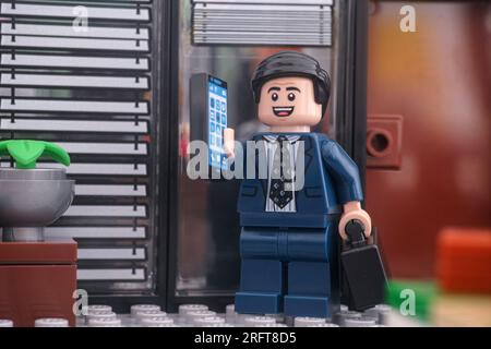 Tambov, Russian Federation - August 04, 2023 A Lego businessman minifigure standing in front of an office door and answering the cellphone. Stock Photo