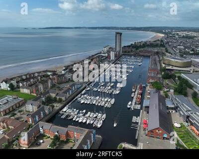 Editorial Swansea, UK - August 04, 2023: Drone view from Swansea Marina to Mumbles lighthouse including the new Swansea Arena Stock Photo