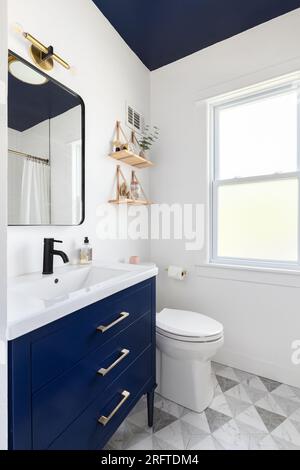 A bathroom with a dark blue cabinet and ceiling, a triangle pattern tile  flooring, and decorations decorations on mounted shelves Stock Photo - Alamy, image size:300x470