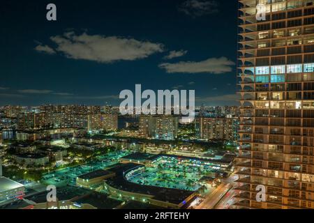High angle view of brightly illuminated residential high-rise building at night in Sunny Isles Beach city in Florida, USA. Housing development in Stock Photo