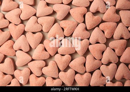 Many heart shaped vitamins for pets on beige background, flat lay Stock Photo
