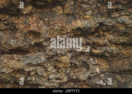 Stone background, rock wall backdrop with rough texture. Abstract, grungy and textured surface of stone material. Nature detail of rocks. Stock Photo