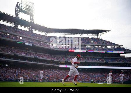 Philadelphia Phillies - Brandon Marsh looking excited, while holding the  end of a baseball bat in his right hand. He is wearing batting gloves, a  long sleeve red shirt, a red hat