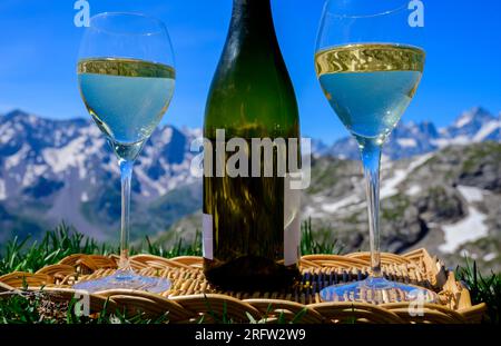 Glass and bottle of dry white Roussette de Savoie or Vin de Savoie wine from Savoy region served on Col du Galibier border Savoy region, France, view Stock Photo