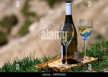 Glass and bottle of dry white Roussette de Savoie or Vin de Savoie wine from Savoy region served on Col du Galibier border Savoy region, France, view Stock Photo