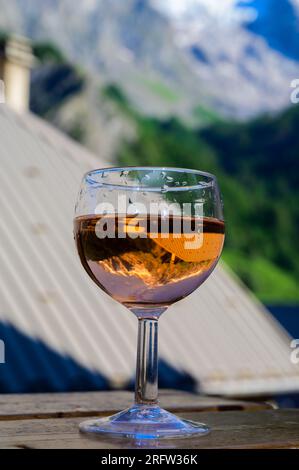 Drinking of dry dry rose wine from Savoy region with view on Hautes Alpes mountains with snow on tops Stock Photo