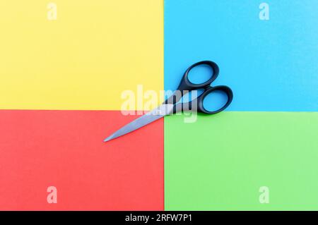 Scissors placed on colored papers, after some edits. Stock Photo