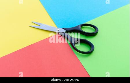Scissors placed on colored papers, after some edits. Stock Photo